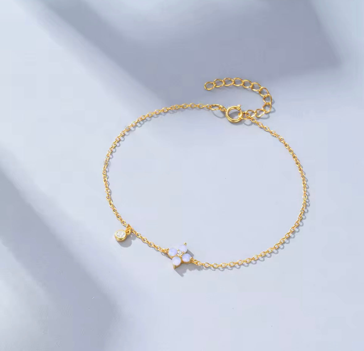 Flower and charm pendant gold bracelet